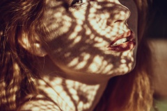Portrait of a charming young woman outdoor. Light and shadow.